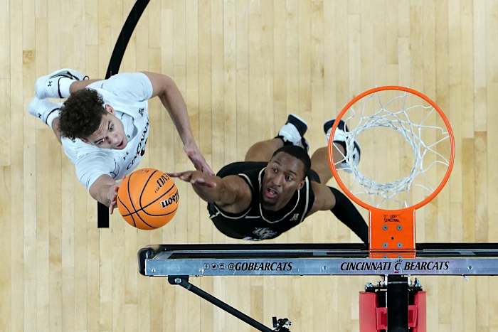 Cincinnati Bearcats guard Dan Skillings Jr. (0) rises to the basket as UCF Knights guard C.J. Kelly (13) defends in the first half of a college basketball game between the UCF Knights and the Cincinnati Bearcats, Saturday, Feb. 4, 2023, at Fifth Third Arena in Cincinnati. The Cincinnati Bearcats won, 73-64. Ucf Knights At Cincinnati Bearcats Feb 4 1196